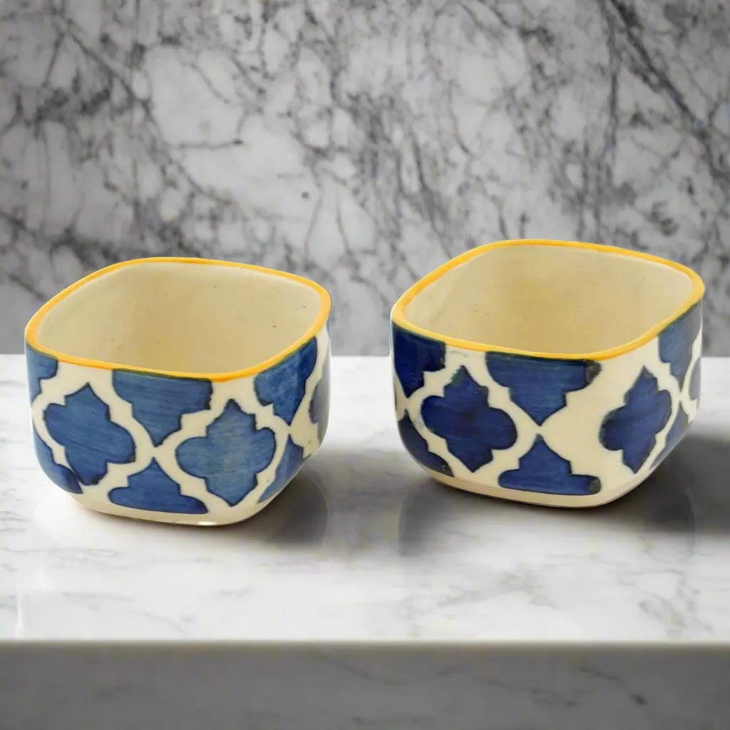 Two ceramic bowls with blue geometric pattern on a marble surface