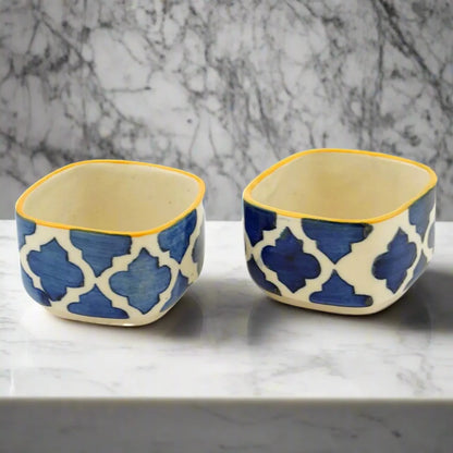 Two ceramic bowls with blue geometric pattern on a marble surface